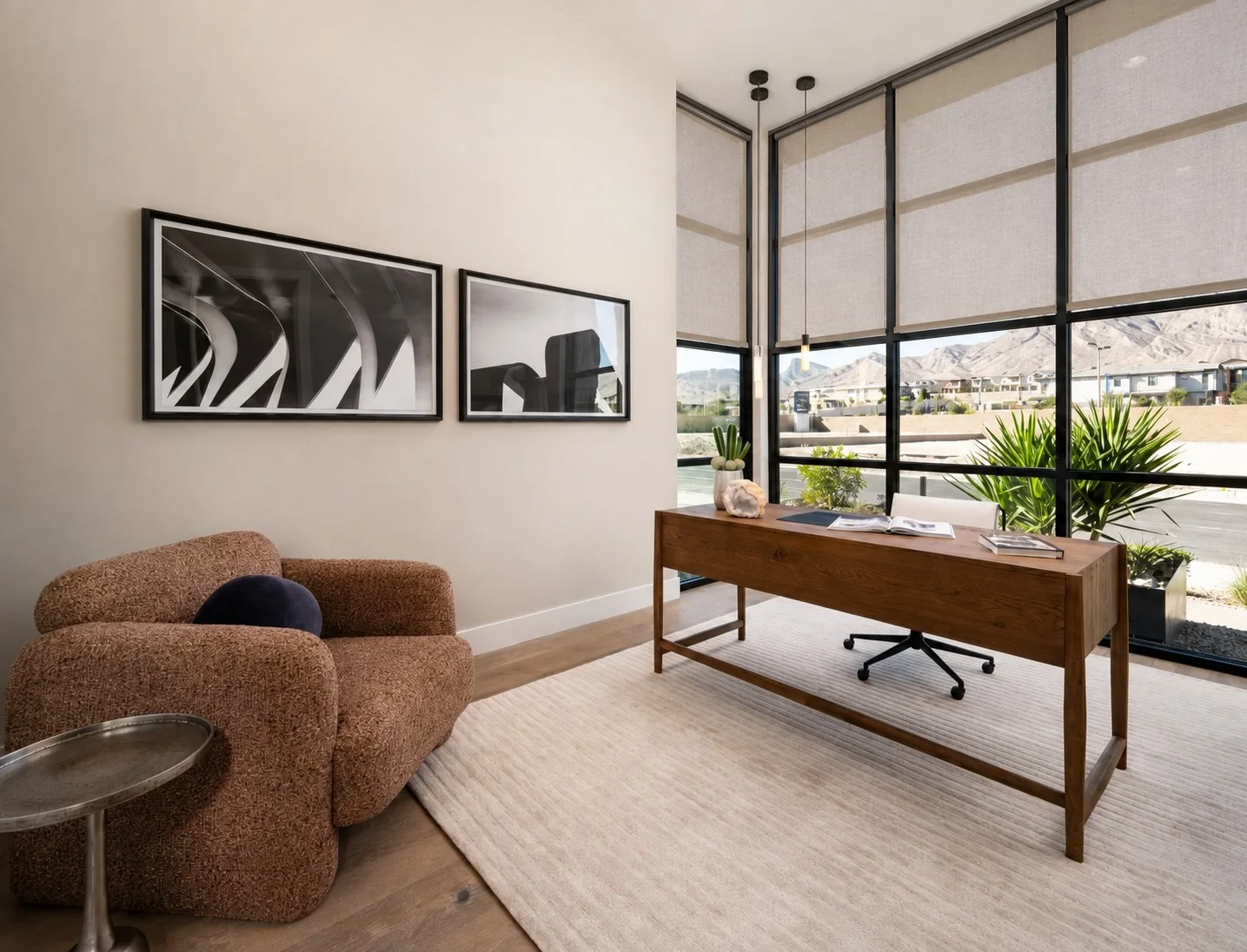 Light roller shades on corner windows beside a wood desk in a home office