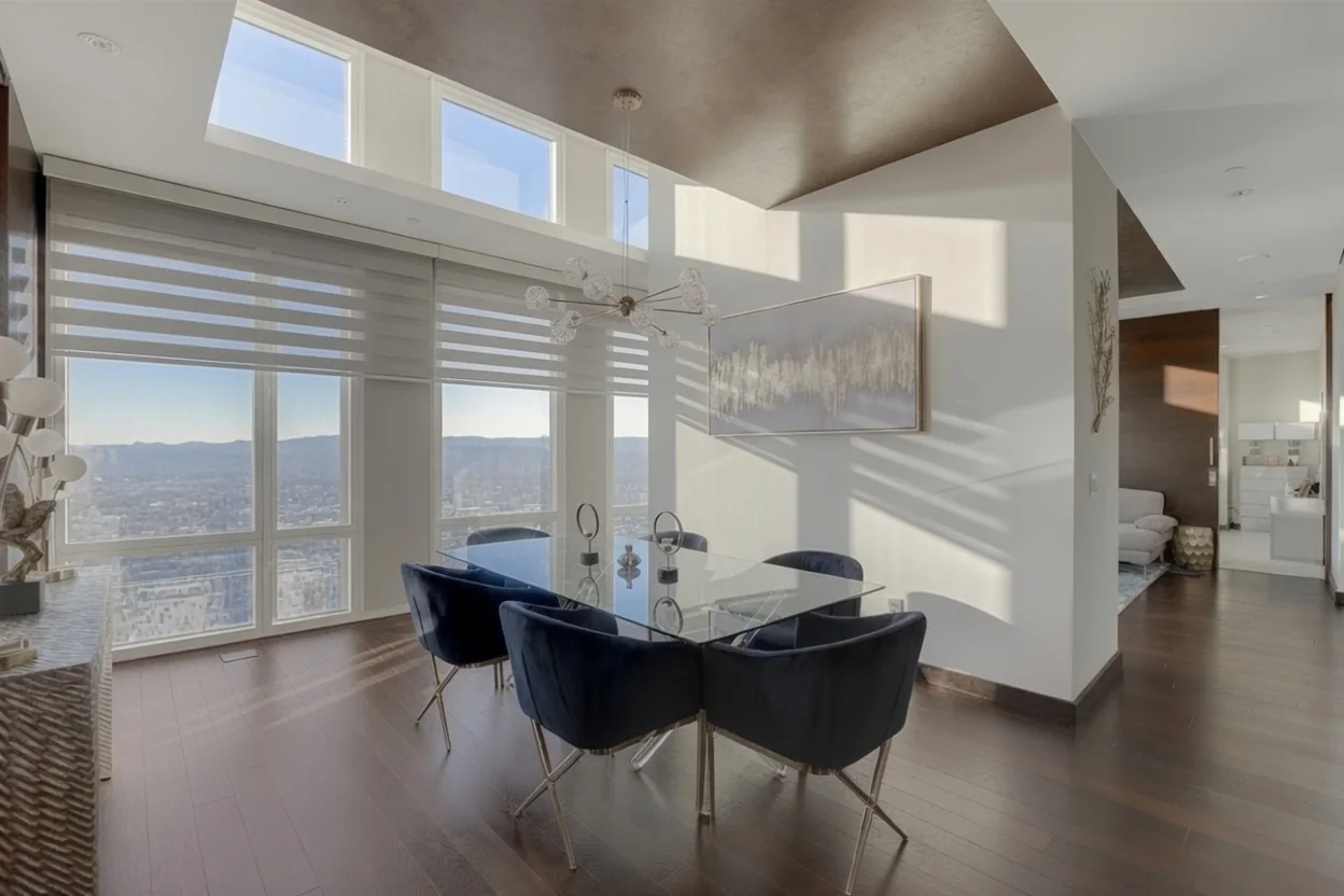 Zebra shades in a high-rise dining room with blue upholstered chairs
